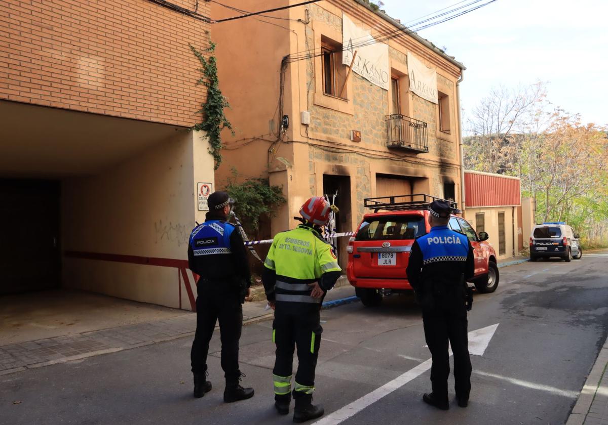 Policías locales, bomberos y agentes nacionales, inspeccionan la casa okupa incendiada esta madrugada.