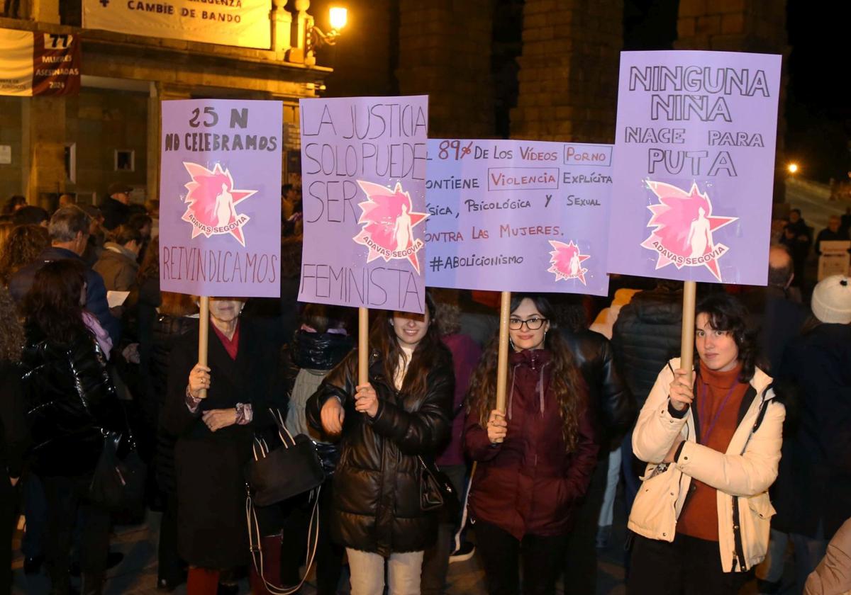 Mujeres muestran carteles con lemas por el 25-N en la concentración que ha tenido lugar este lunes en Segovia.