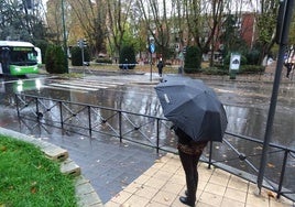 Una mujer observa la balsa de agua que cortó el paso peatonal de la avenida de Medina del Campo por la mañana.