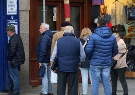 Varias personas hacen cola a las puertas de una administración de lotería en la provincia.