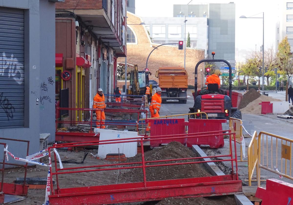 Los operarios trabajan en el adoquinado de las aceras del lado de las viviendas de la calle Transición.