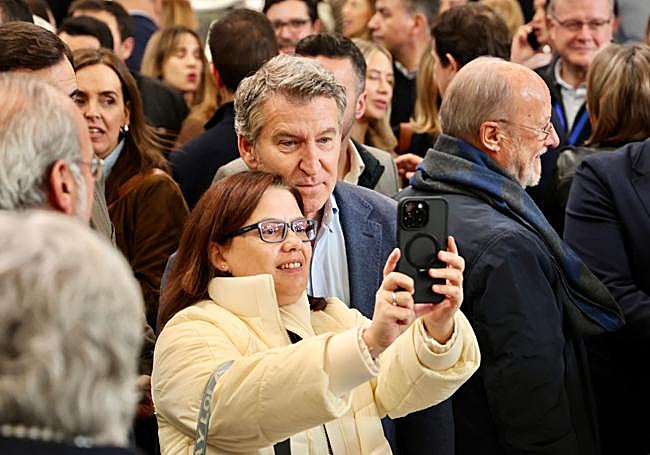 Una asistente se hace una foto con Feijóo. Tras ellos, Javier León de la Riva, exalcalde de Valladolid.