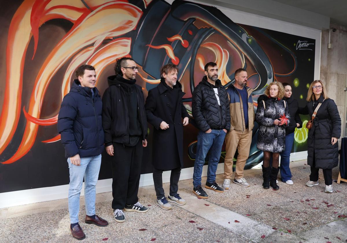 Representantes del Ayuntamiento posan con los artistas ante el mural.