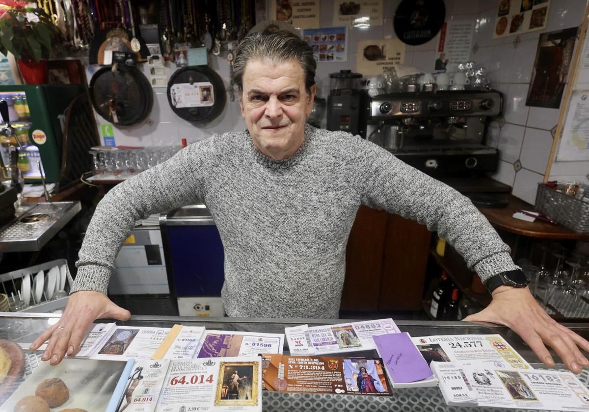 José Luis Calleja muestra las participaciones de las cofradías que vende en su taberna.