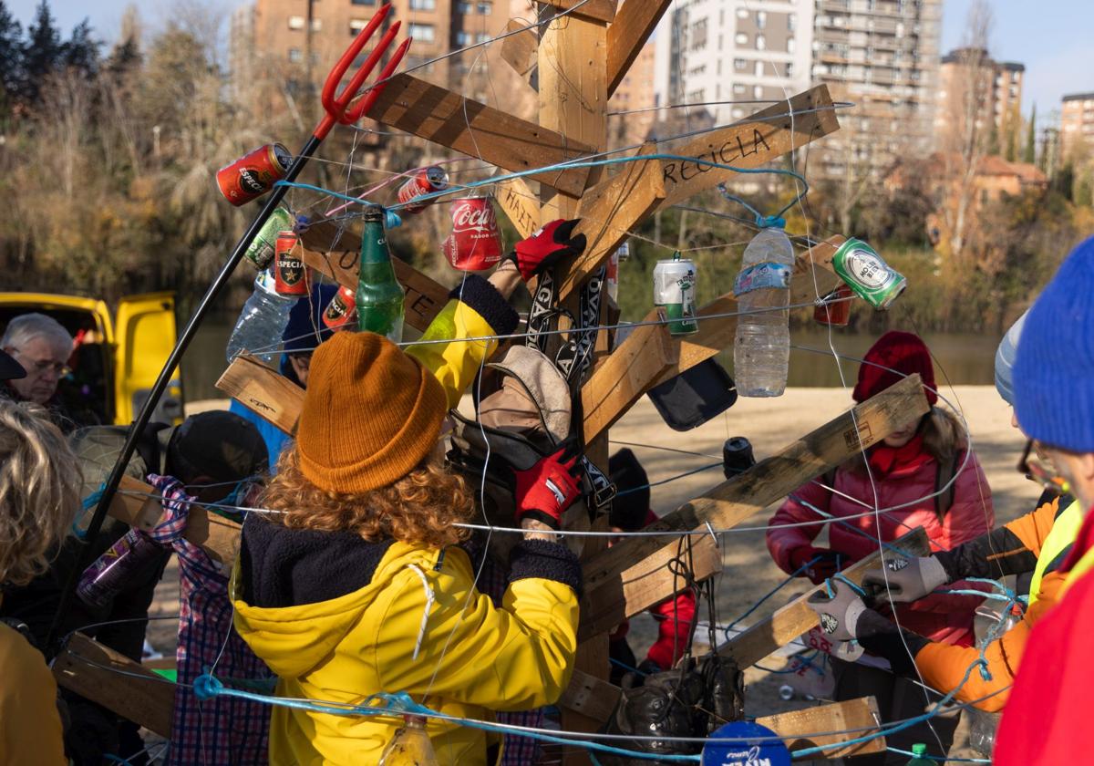 Los voluntarios de la asociación AMA El Pisuerga adornan el árbol en la playa de Las Moreras.