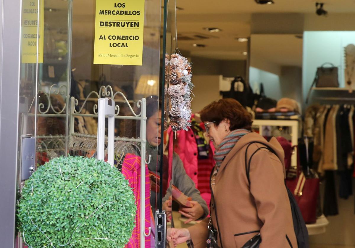 Cartel reivindicativo colgado en el escaparate de una tienda de ropa.