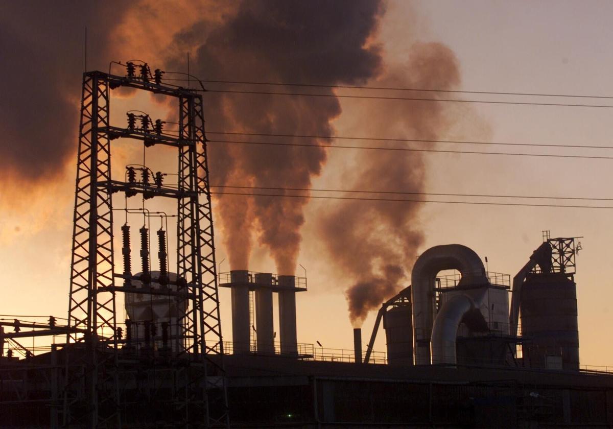 Una planta industrial soltando gases a la atmósfera.