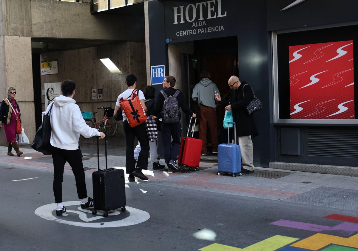 Viajeros entran al hotel Alda, en la calle Eduardo Dato, el pasado puente de Los Santos.