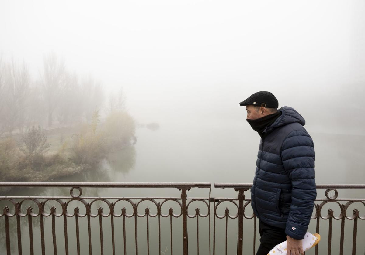 Un hombre camina entre la niebla por un puente en Valladolid, hace unos días.