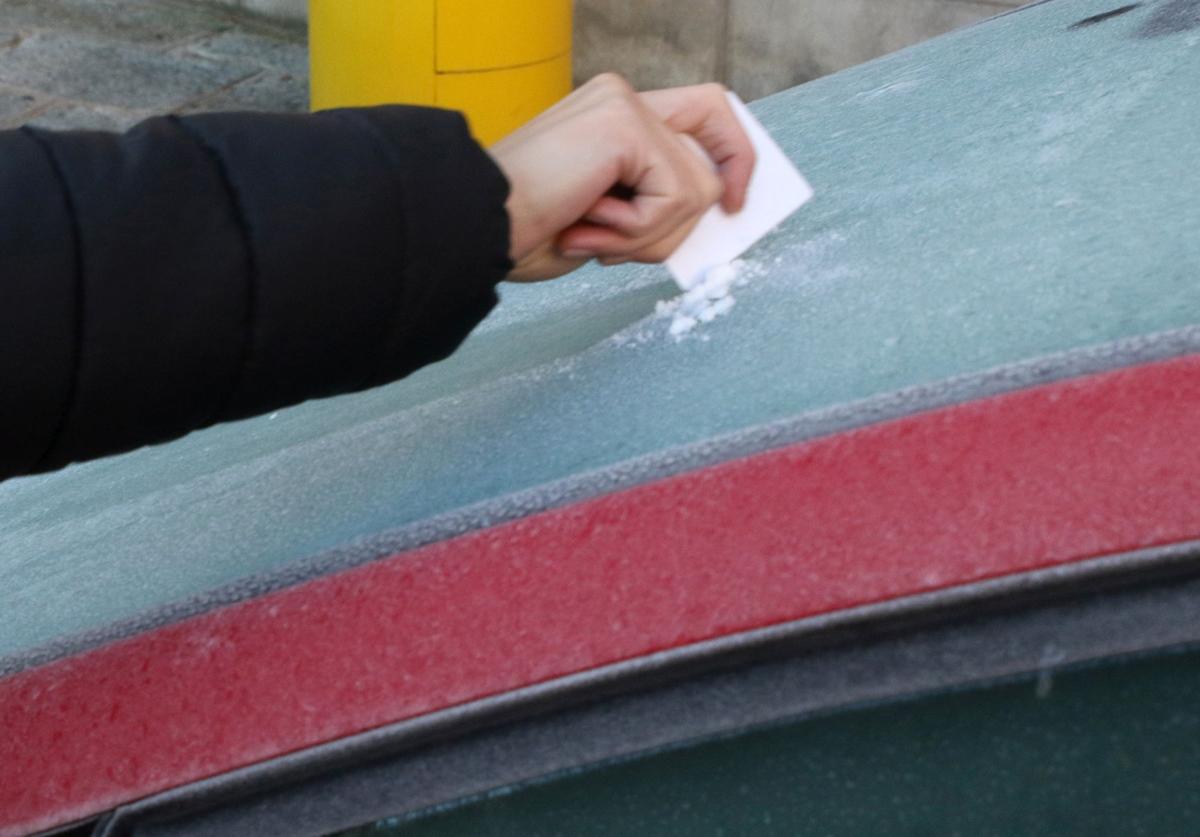 Una persona retira hielo de la luna de un coche, en una imagen de archivo.