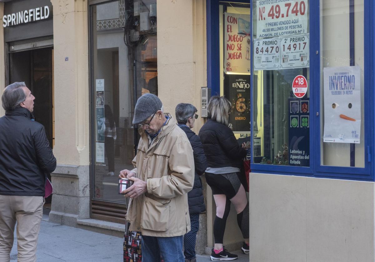 Varias personas esperan su turno para acceder a una administración de lotería del centro de Segovia.