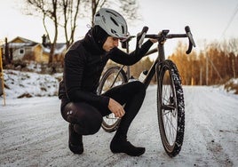 Daniel revisa las ruedas de su bicicleta en una carretera de Suecia.