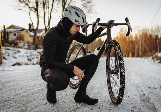 Daniel revisa las ruedas de su bicicleta en una carretera de Suecia.