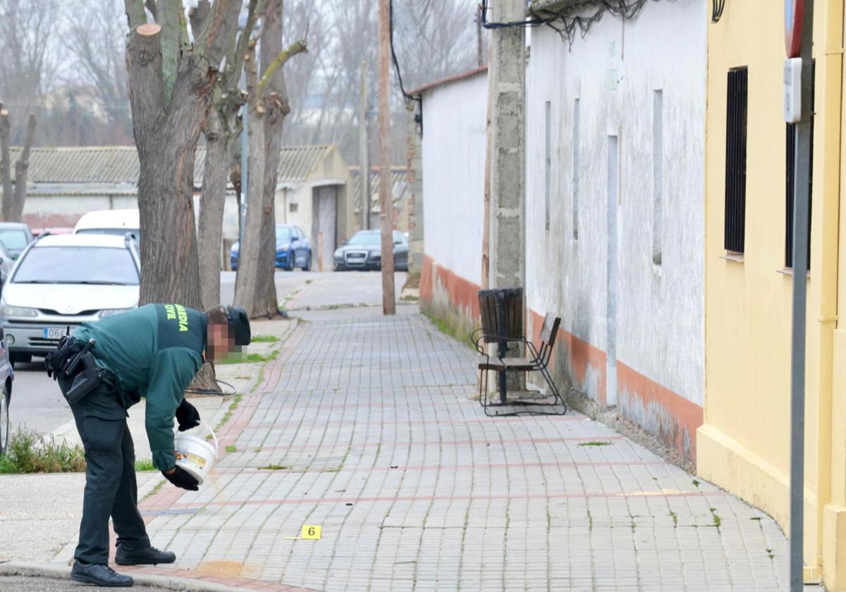 Un agente de la Guardia Civil esparce arena en el lugar de los hechos, en el cruce de las calles Butacas y Cestero.