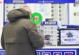 Un hombre compra lotería para el sorteo de El Niño en una administración de Valladolid.