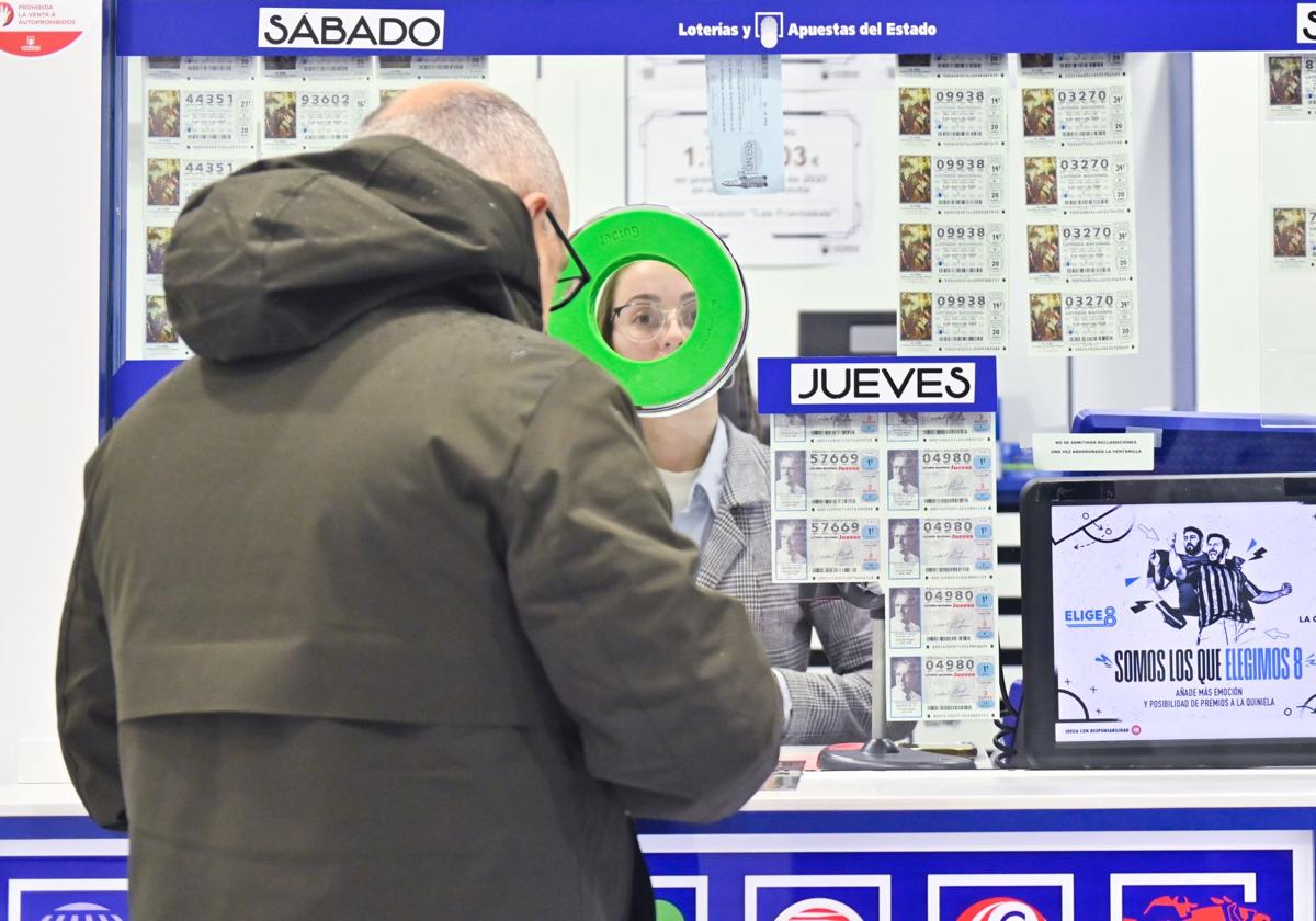 Un hombre compra lotería para el sorteo de El Niño en una administración de Valladolid.