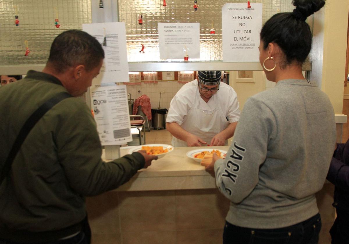 Un cocinero sirve menús en el comedor social de la ciudad de Segovia.