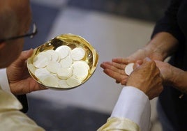 Un sacerdote entrega en la mano la comunión en una iglesia de Segovia.