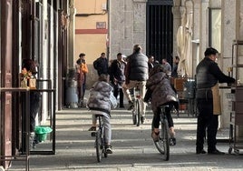 Un adulto y dos niños circulan en bicicleta por la Plaza Mayor de Segovia.