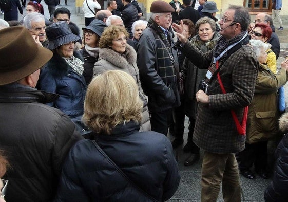 Un guía oficial habla del teatro Cervantes a un grupo de turistas, en la Calle Real de Segovia.