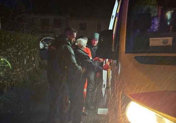 Miembros del operativo ayudan al hombre a subir a la ambulancia.