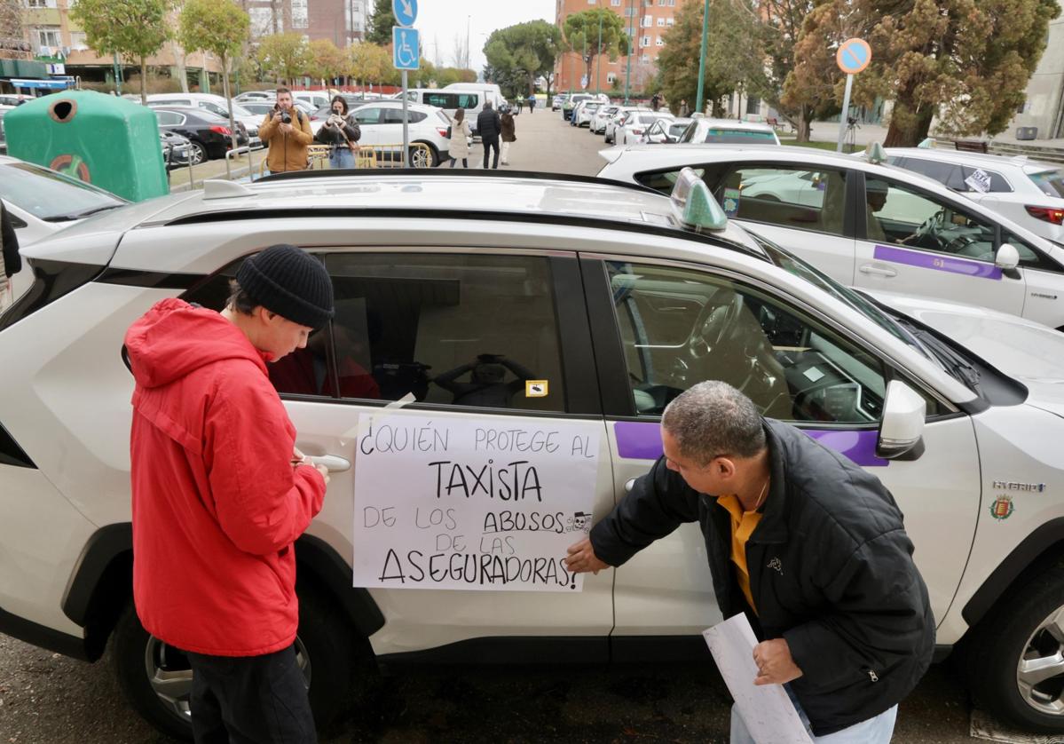 Un taxista coloca un cartel en el lateral de su vehículo, este miércoles durante la manifestación en Valladolid.