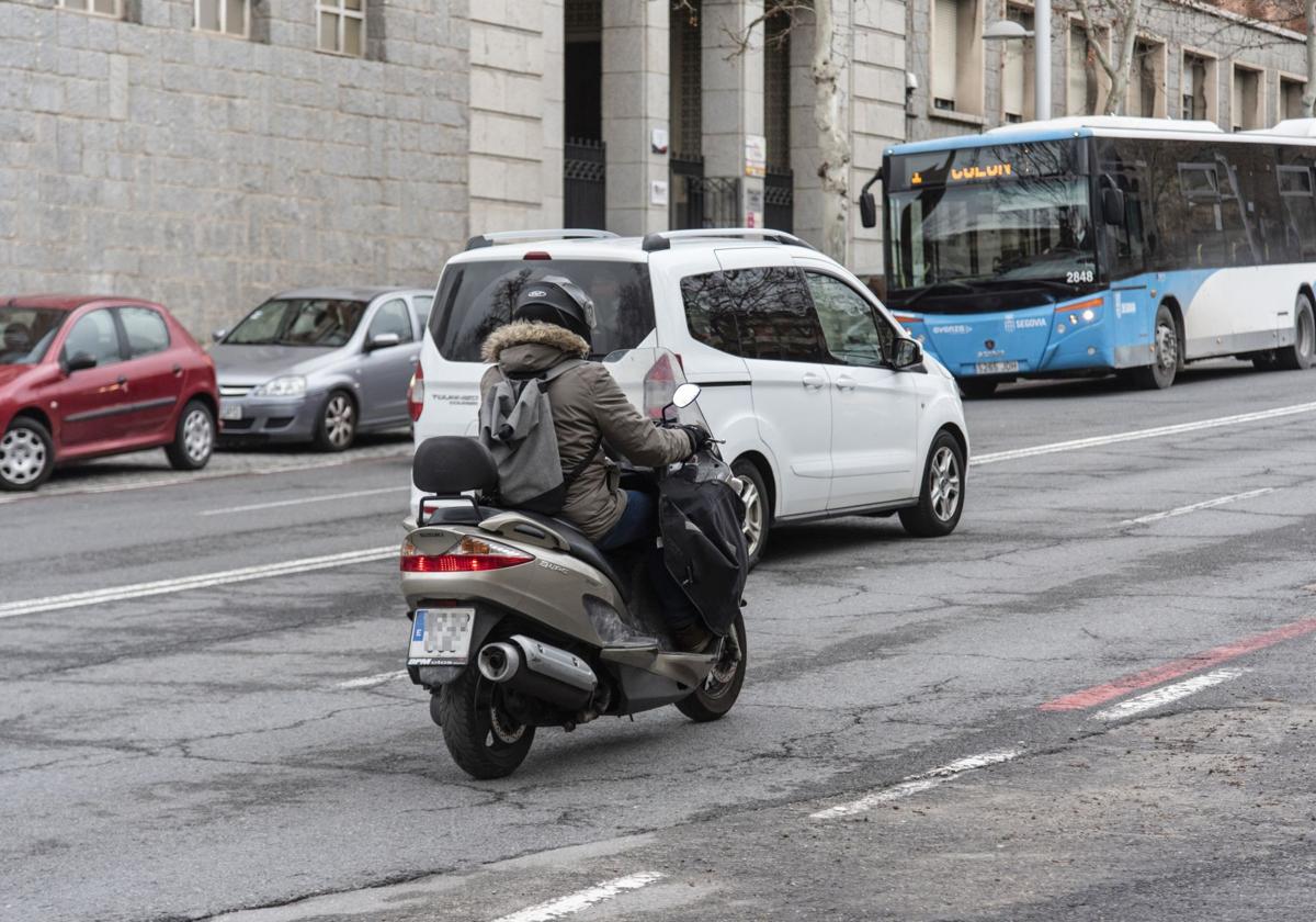 Un conductor circula en motocicleta por una de las vías principales de la ciudad de Segovia.