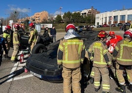 Sanitarios y bomberos asisten a los ocupantes de uno de los dos vehículos volcados.