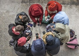 Adolescentes usan sus teléfonos móviles.