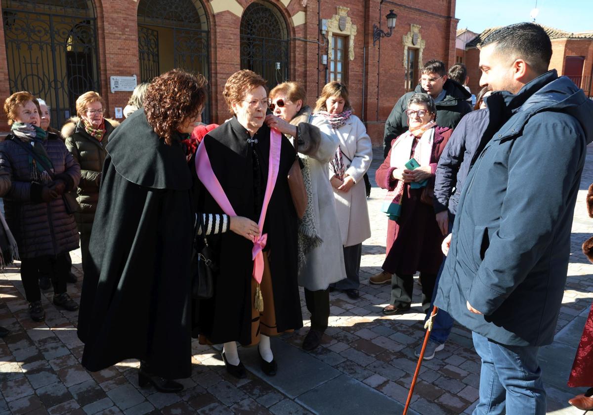 El alcalde de Becerril observa cómo colocan la banda rosa a Pilar Sangrador, Águeda 2025.