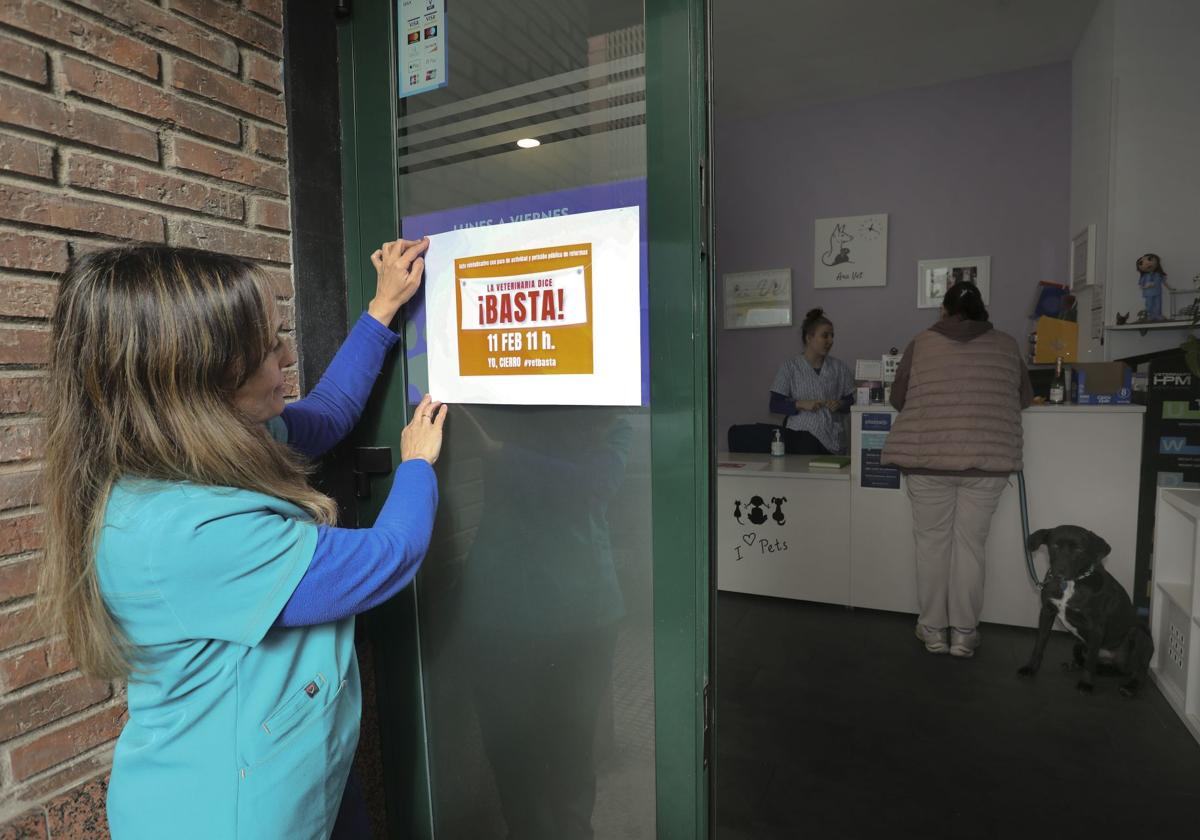 Ana Magaz coloca el cartel de protesta en su clínica, en la calle Villacasares.