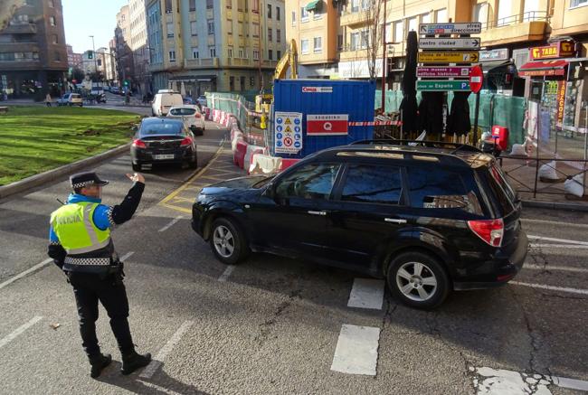 Un agente regula el tráfico en la salida de la calle Tudela a la plaza de la Circular.