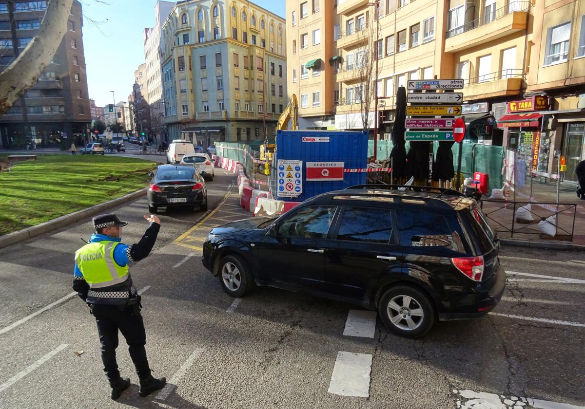 Un policía municipal regula el tráfico en la plaza Circular, que tiene un carril cortado por las obras para desmantelar la antigua gasolinera.