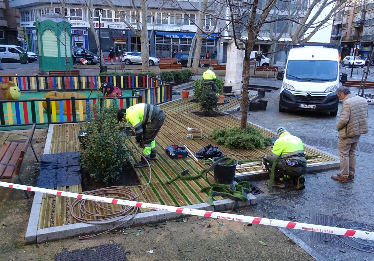 Los operarios rematan el ajardinamiento del parterre cubierto con una tarima de madera de la plaza de Caño Argales.