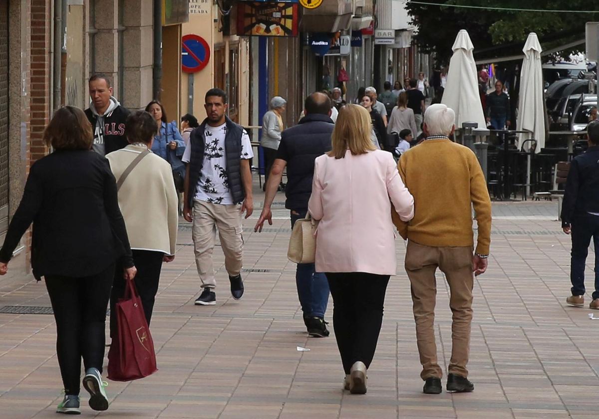 Varias personas pasean por una calle de la ciudad de Segovia.