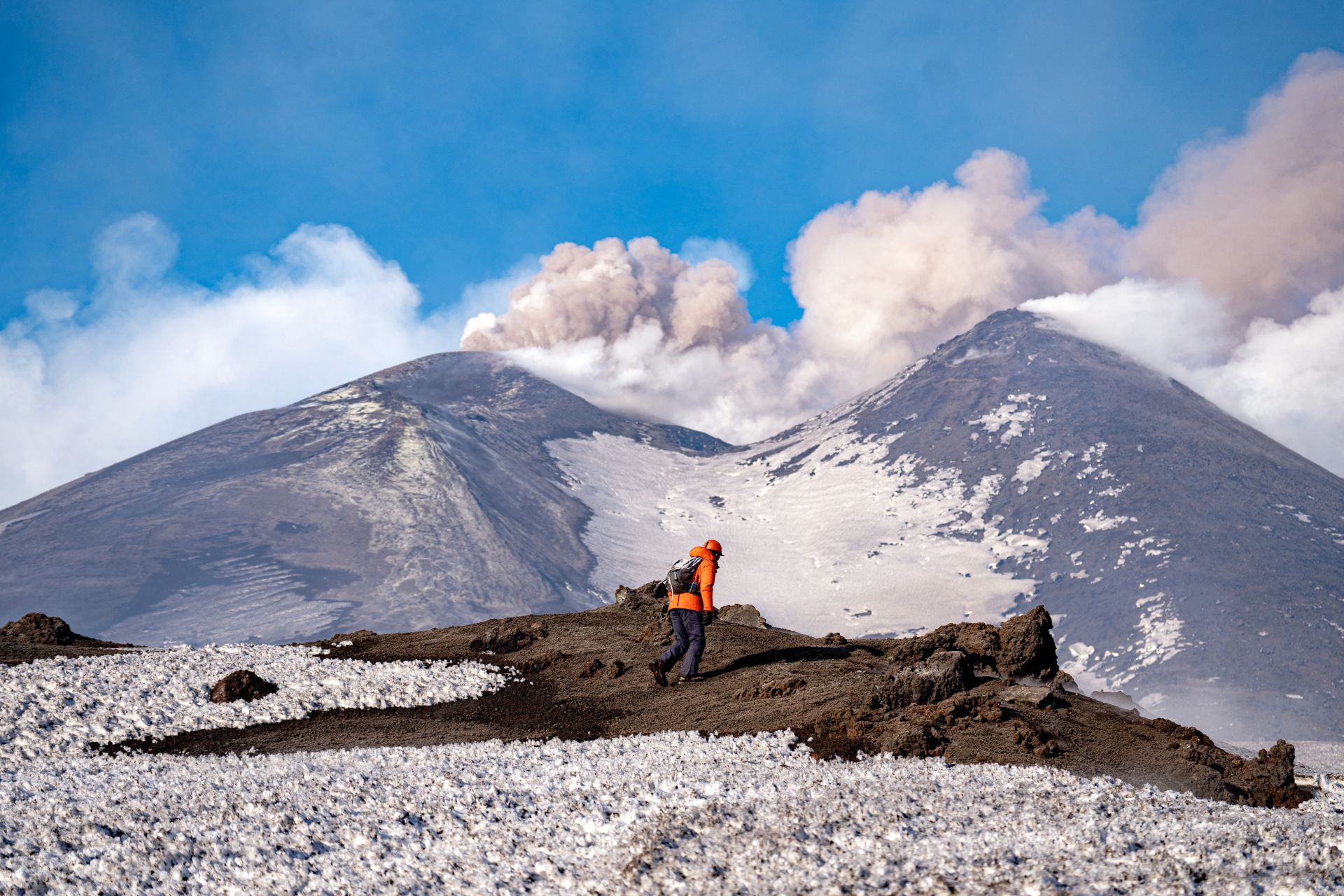 Un hombre mirando el volcán mientras erupciona