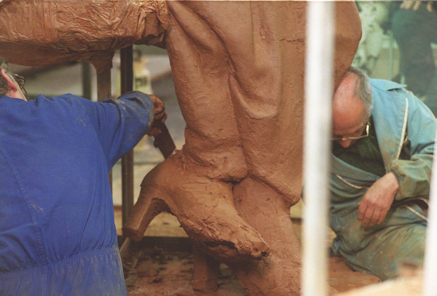 Detalle y trabajos de creación en los pies de la escultura en homenaje a los Reyes de España.