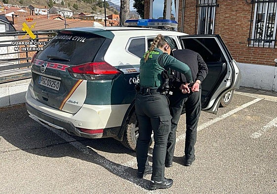 La Guardia Civil introduce al detenido en un vehículo patrulla.