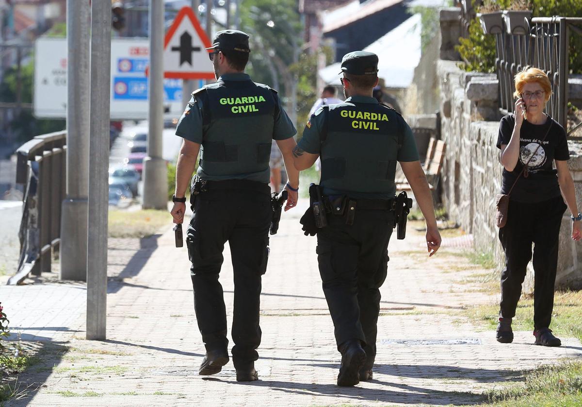 Dos guardias civiles caminan por la travesía de San Rafael.