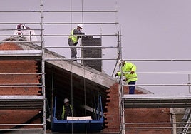 Obreros en el tejado de un edificio en construcción en Segovia.