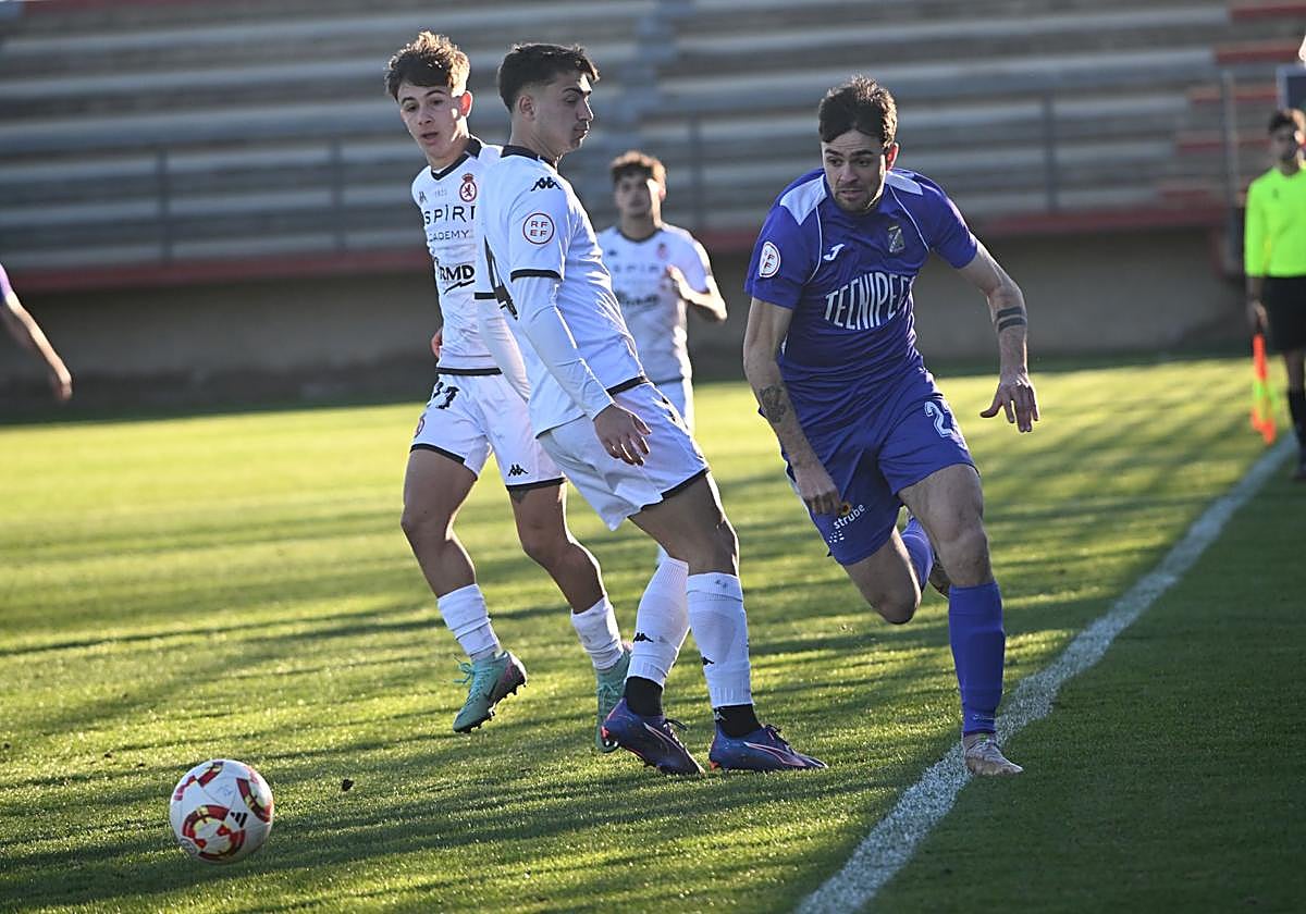 Kuko intenta llevarse un balón por la banda anda dos rivales del Júpiter Leonés.