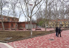 Dos vecinos pasean por el nuevo corredor de la calle Alpujarras que rodea la remozada plaza del Marqués de Suances.