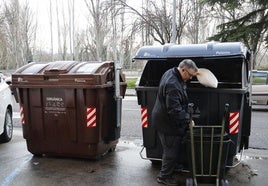 Un hombre deposita basura en el contenedor gris, junto a uno de los marrones, en Santiago Amón.