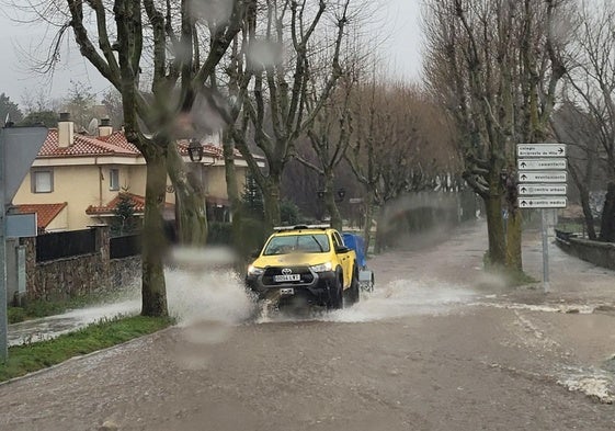 Un vehículo de Protección Cvil, circula por una calle anegada en El Espinar este sábado