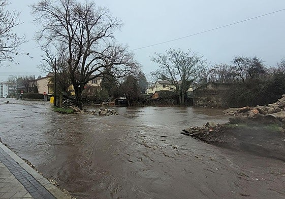 Riada de agua y barro en una calle de El Espinar, este sábado.