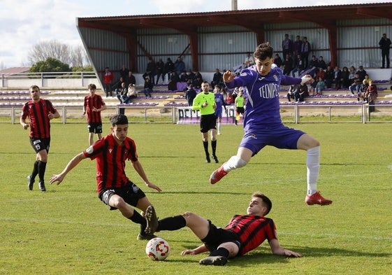 Bonalde salta para salvar la entrada de un rival en el partido entre el Becerril y el Laguna.