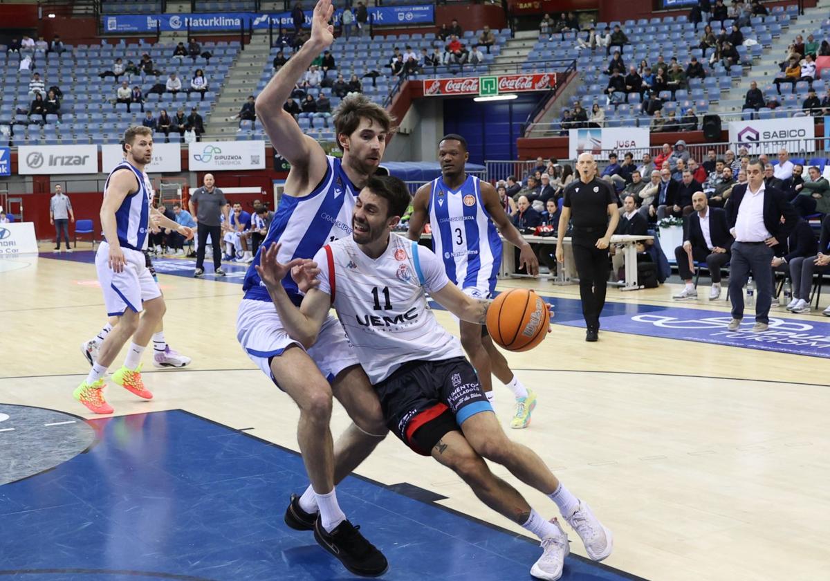 Manchón trata de entrar a canasta mientras se queja de una falta de Javier Nicolau.