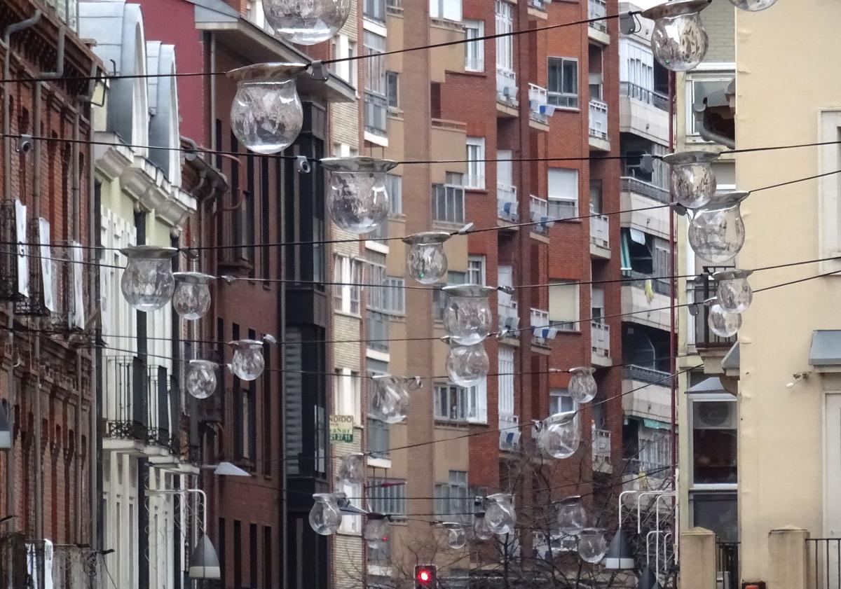 Imagen principal - Arriba, la malla de luces colgantes de la calle Mantería antes de su encendido. Debajo, a la izquierda, detalle de una de las 'gotas' y, detrás, de los focos ornamentales en la fachada del número 13. A la derecha, la luminaria de las nuevas farolas de la plazoleta de San Andrés.