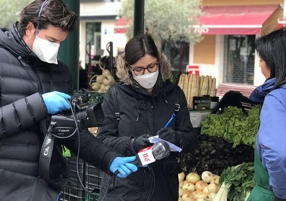 Los periodistas de El Norte Eva Esteban y Rodrigo Ucero entrevistan a una trabajadora del mercado de la Plaza España durante la pandemia.