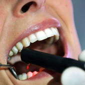 Un dentista realiza una revisión bucodental a una paciente en una imagen de archivo.